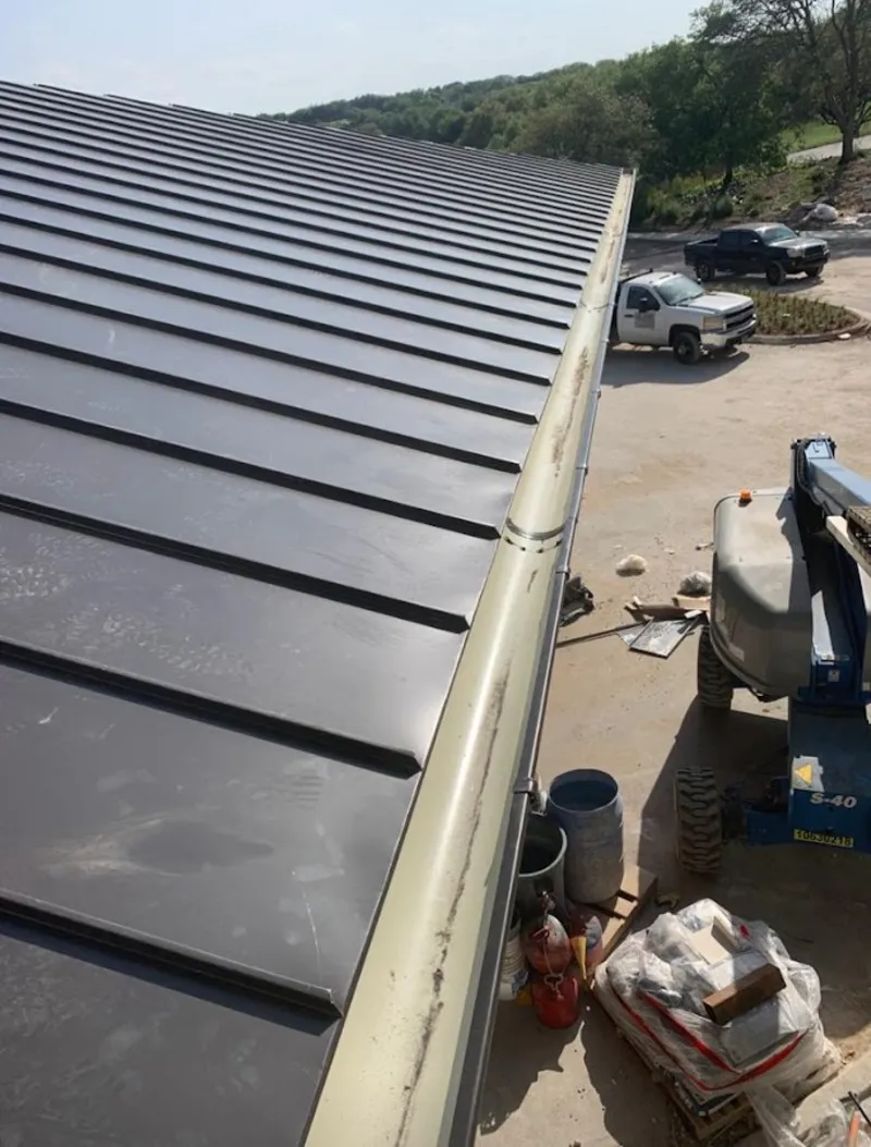 Standing seam panel and gutter detail on a metal roofing jobsite in Boonville